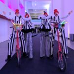 black & white stilt walker on bikes